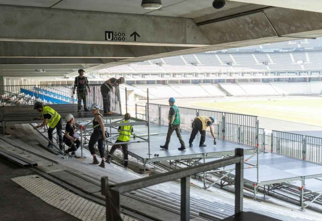 Radnici postavljaju montažni podest na tribinama stadiona
