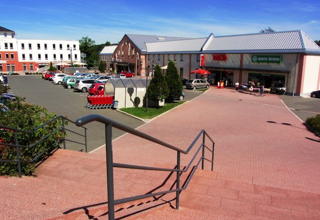 Tržni centar sa parkiralištem i stepeništem u prvom planu